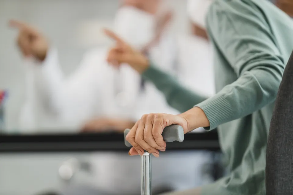 Zorgverlener ondersteunt een oudere vrouw met een rollator