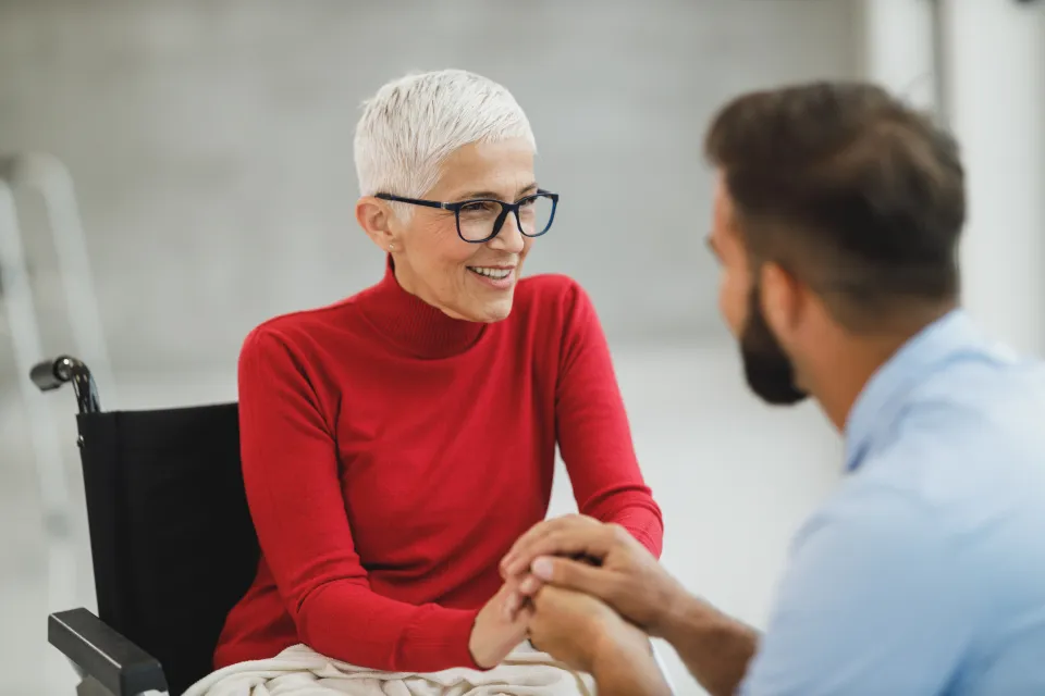 Oudere vrouw lacht tijdens een gesprek met haar zorgverlener